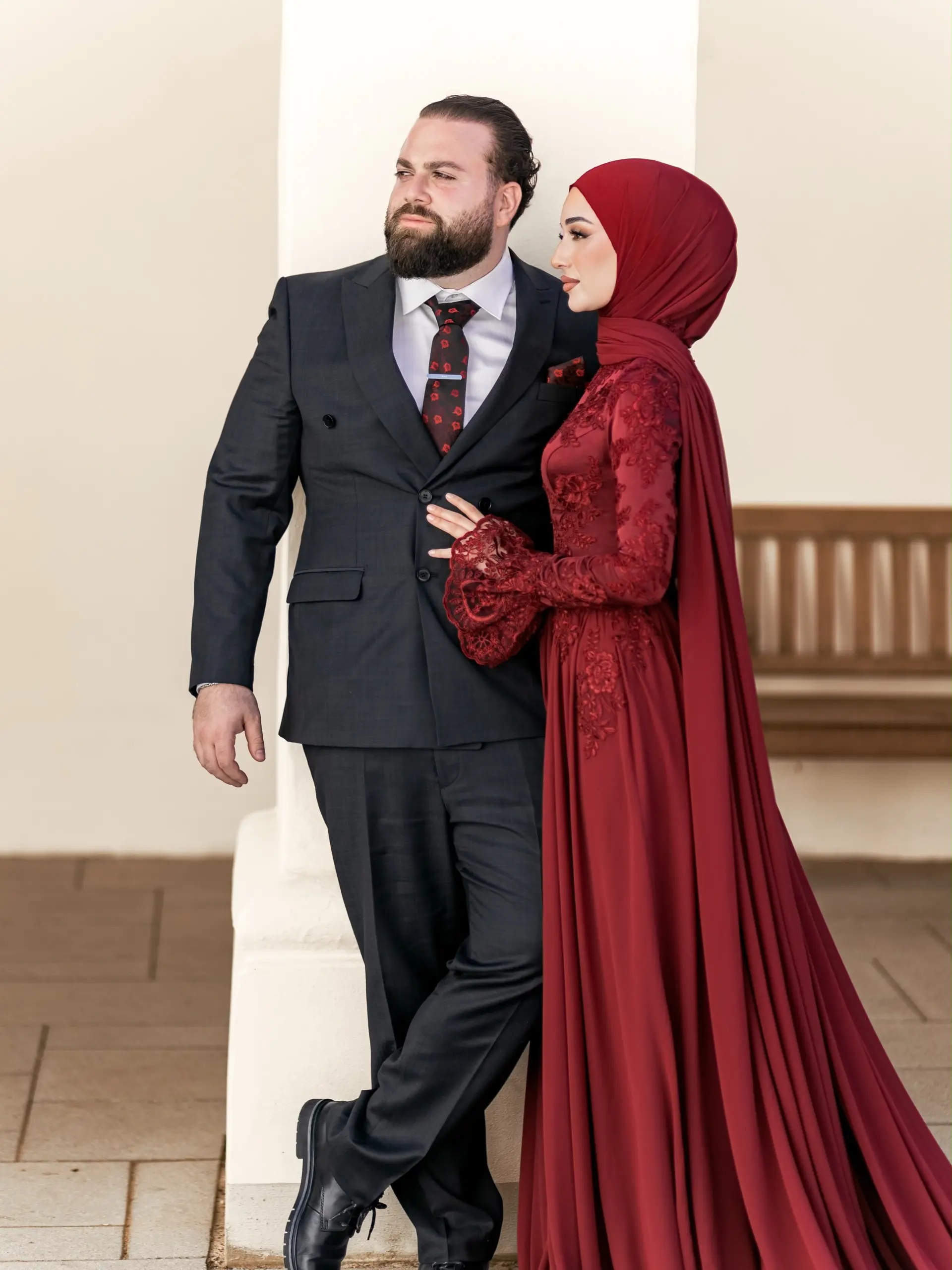 Paar im Profil: Braut mit burgunderrotem Hijab und Spitzenkleid neben dem Bräutigam